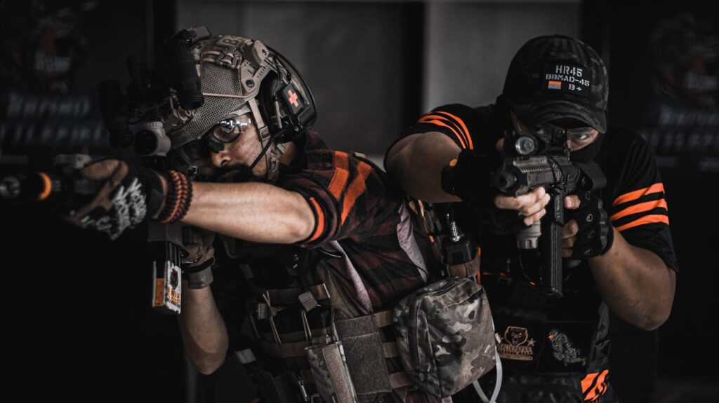 Two Man Pointing Gun Wearing Black And Orange